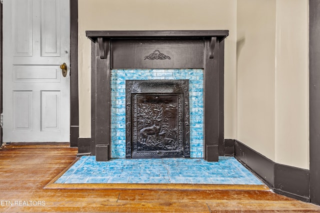 room details featuring wood finished floors and a tile fireplace