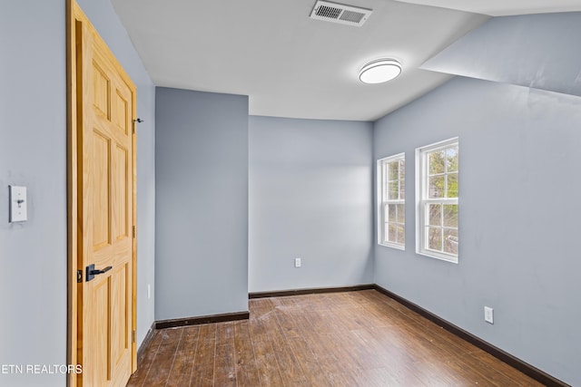 unfurnished bedroom featuring baseboards, dark wood-type flooring, and visible vents