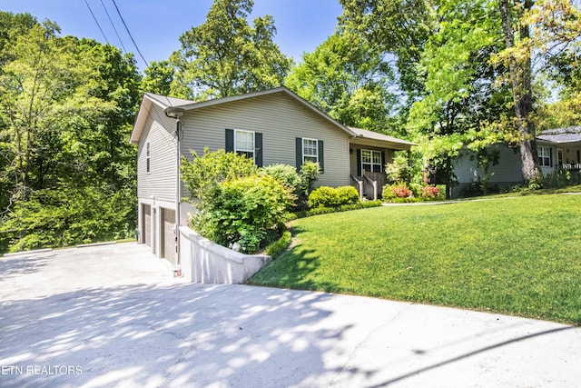 ranch-style house featuring concrete driveway, a front yard, and a garage