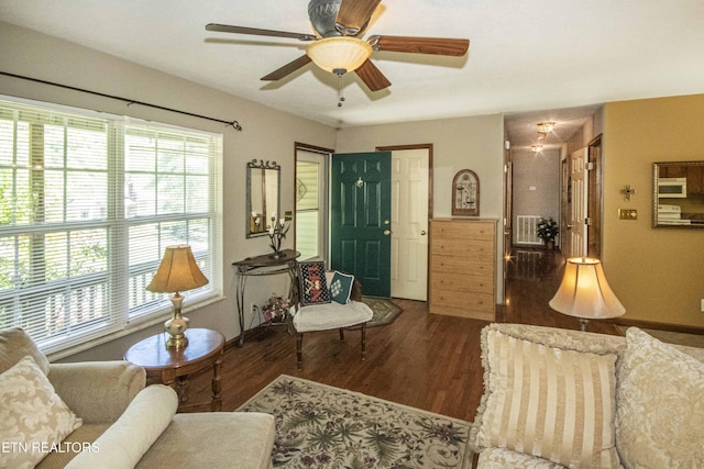 living area with a ceiling fan, baseboards, visible vents, and wood finished floors