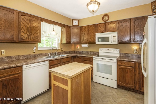 kitchen with brown cabinetry, white appliances, butcher block countertops, a center island, and a sink