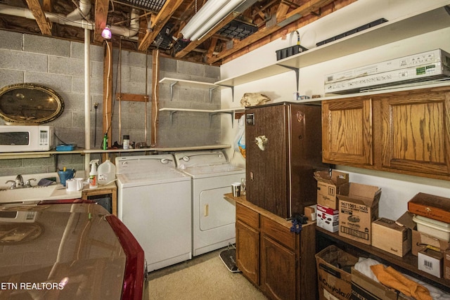 washroom with laundry area, washer and dryer, and concrete block wall