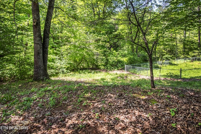 view of yard featuring fence and a wooded view