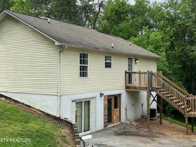 2208 Island Blvd, Sevierville, TN 37876 - rear view of house with stairway, a deck, a shingled roof, a patio, and view of wooded area