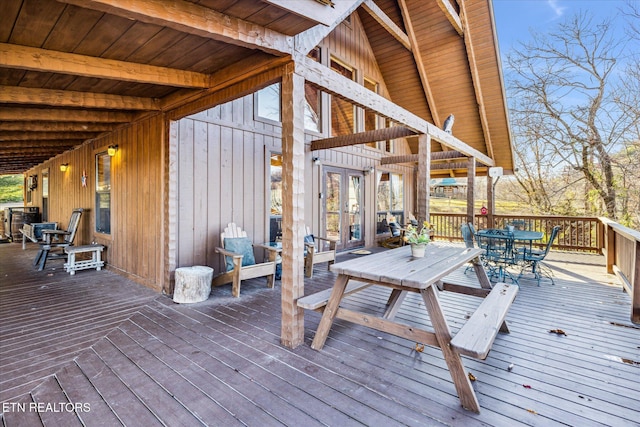 wooden terrace featuring french doors and outdoor dining space