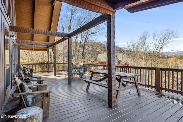 deck with outdoor dining area and a mountain view