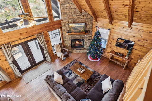living room featuring a fireplace, hardwood / wood-style floors, wooden walls, wood ceiling, and lofted ceiling with beams