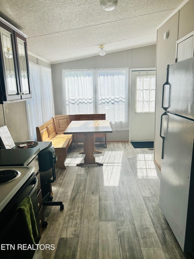 office area with a textured ceiling, wood finished floors, and vaulted ceiling