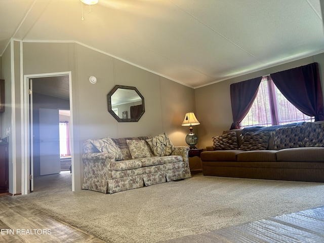 carpeted living room with plenty of natural light, ornamental molding, and lofted ceiling
