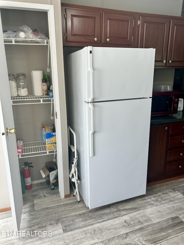 kitchen with freestanding refrigerator and light wood finished floors