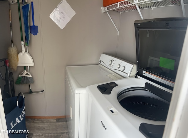 laundry room with laundry area, baseboards, independent washer and dryer, and wood finished floors