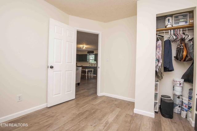 unfurnished bedroom featuring baseboards, a closet, and wood finished floors