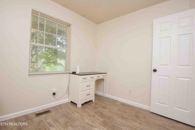 laundry room with light wood-type flooring, baseboards, and visible vents