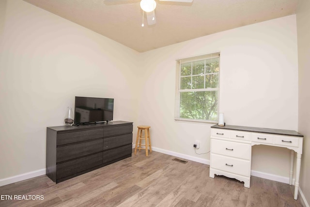 interior space with baseboards, visible vents, ceiling fan, and light wood-style floors