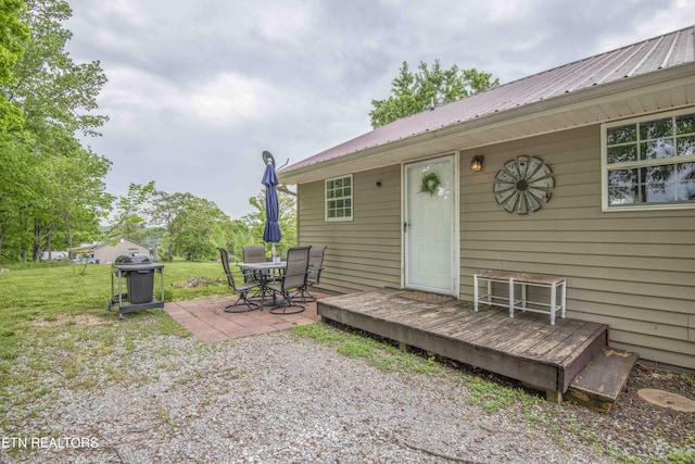 rear view of house featuring a lawn, a patio, metal roof, and a wooden deck