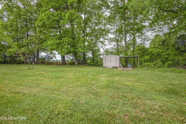 view of yard featuring an outbuilding, fence, and a storage shed