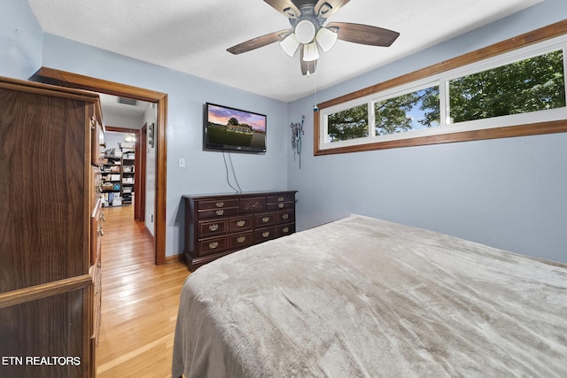bedroom featuring light wood-style floors, a ceiling fan, and visible vents