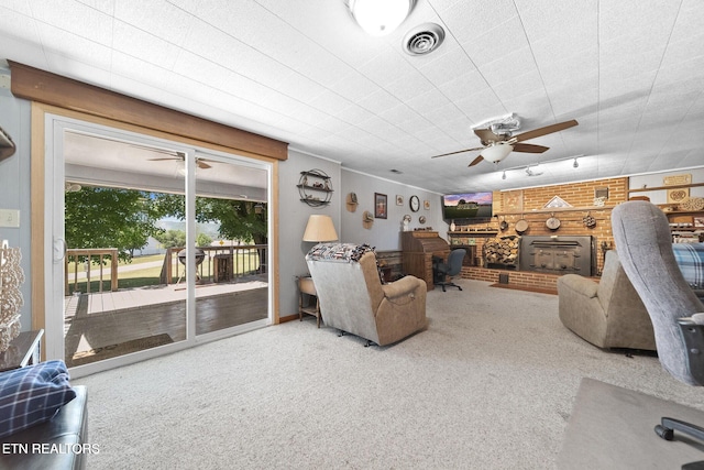 living area with visible vents, carpet flooring, ceiling fan, and a fireplace