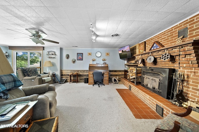carpeted living area with ceiling fan, visible vents, and a fireplace