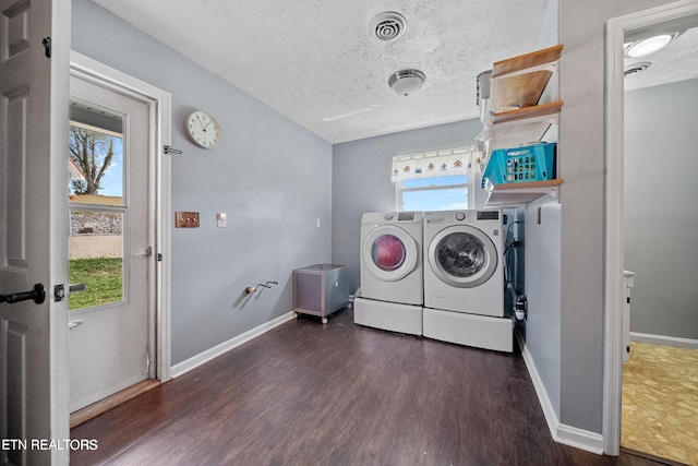 washroom with laundry area, washing machine and dryer, a healthy amount of sunlight, wood finished floors, and a textured ceiling