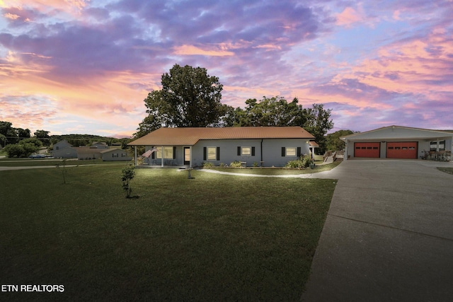 ranch-style house featuring a porch, driveway, a front yard, and metal roof