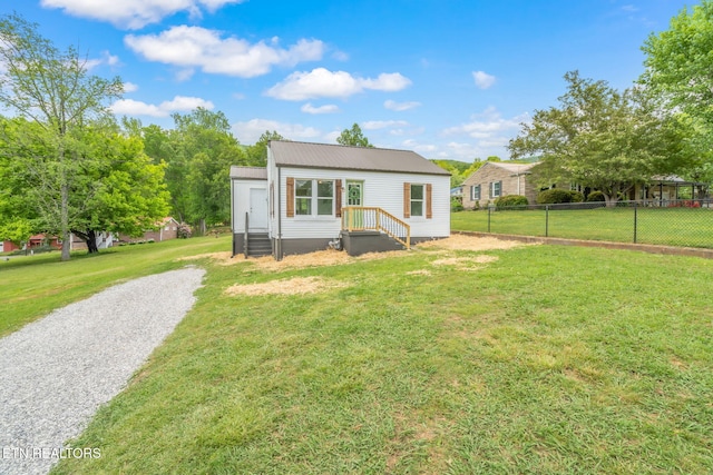 309 Evergreen St, Harriman, TN 37748 - rear view of property featuring a lawn, fence, and metal roof
