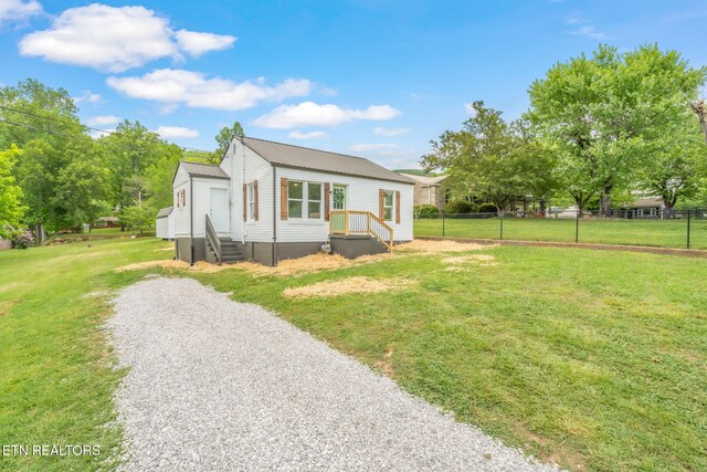 309 Evergreen St, Harriman, TN 37748 - view of front facade with fence, metal roof, driveway, and a front lawn