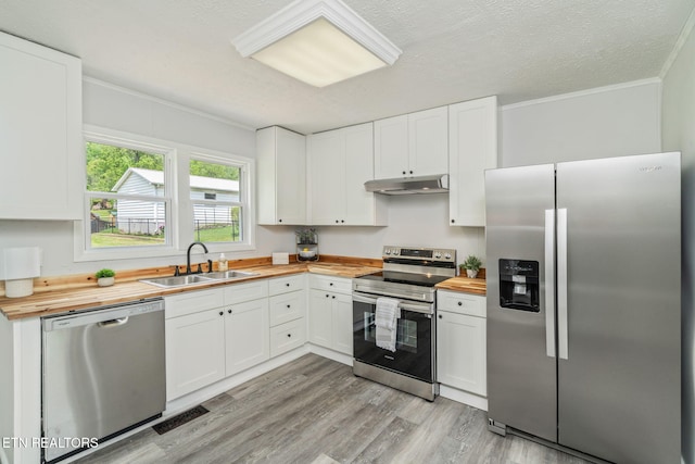 309 Evergreen St, Harriman, TN 37748 - kitchen featuring crown molding, appliances with stainless steel finishes, a sink, butcher block counters, and under cabinet range hood
