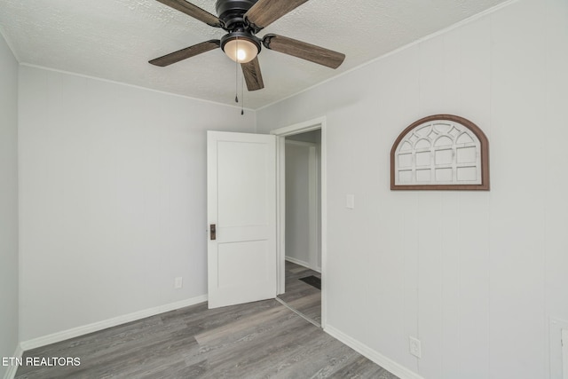 309 Evergreen St, Harriman, TN 37748 - unfurnished bedroom with baseboards, a ceiling fan, a textured ceiling, and wood finished floors