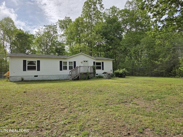 manufactured / mobile home with crawl space, a wooden deck, and a front lawn