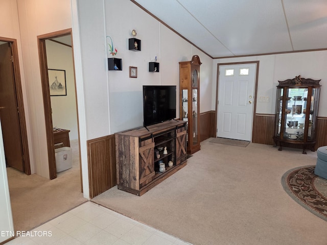 carpeted living room with wainscoting, vaulted ceiling, and wooden walls
