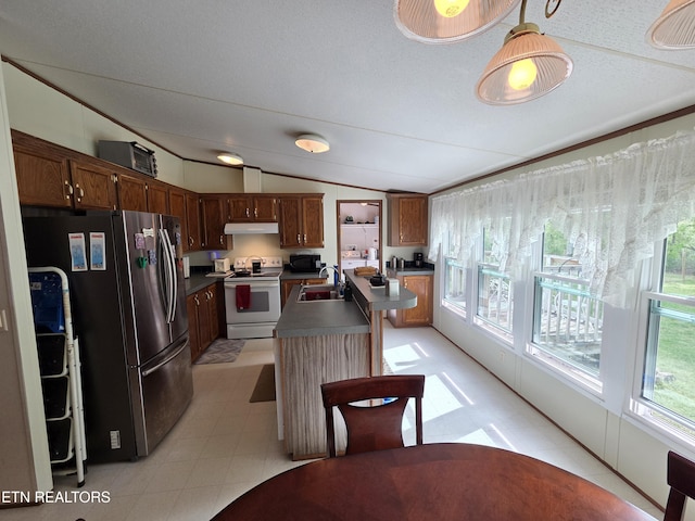 kitchen with freestanding refrigerator, dark countertops, under cabinet range hood, white range with electric stovetop, and a sink