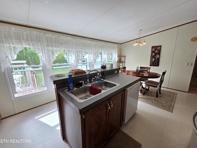 kitchen with white dishwasher, dark brown cabinets, an inviting chandelier, a sink, and an island with sink