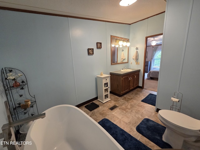 ensuite bathroom featuring crown molding, vanity, toilet, a freestanding tub, and visible vents