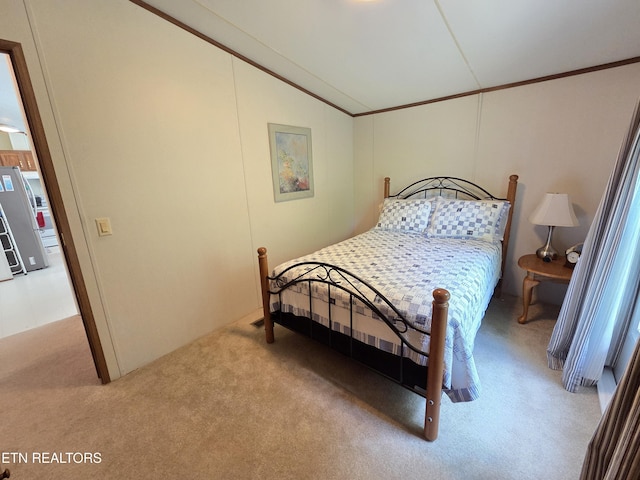 carpeted bedroom with ornamental molding, lofted ceiling, and freestanding refrigerator