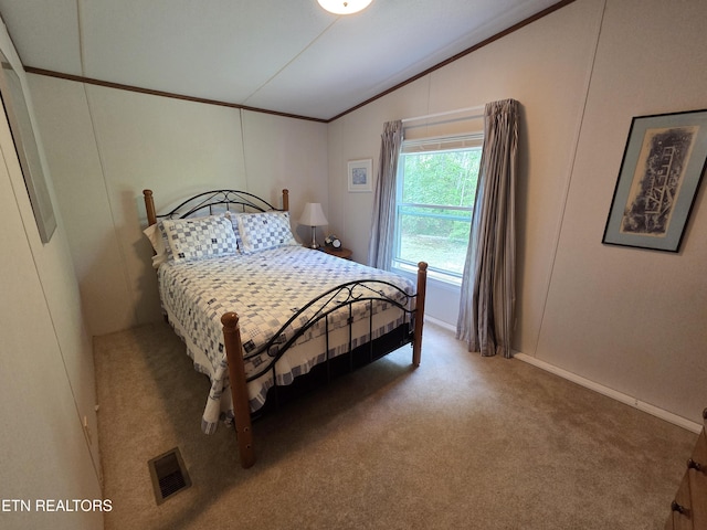 carpeted bedroom featuring visible vents, baseboards, crown molding, and vaulted ceiling