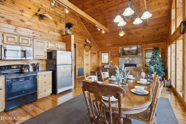 dining space featuring light wood-style floors, high vaulted ceiling, wood walls, ceiling fan with notable chandelier, and wood ceiling