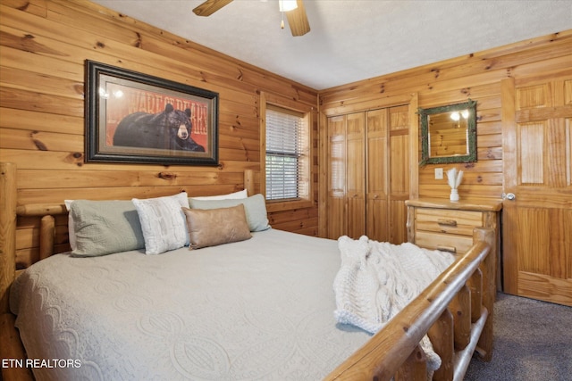 bedroom with carpet floors, a ceiling fan, and wooden walls