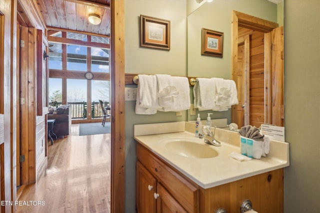 bathroom with a healthy amount of sunlight, vanity, and wood finished floors