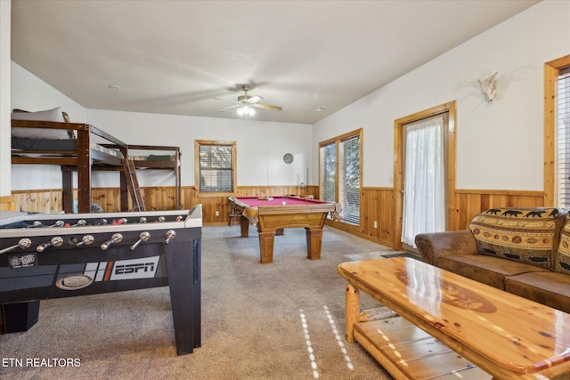 recreation room featuring wainscoting, light carpet, wood walls, a ceiling fan, and pool table