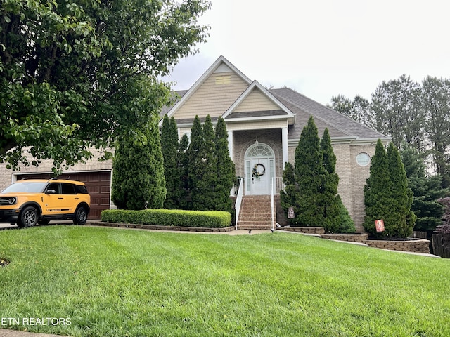 view of front facade with a shingled roof, a front lawn, and brick siding