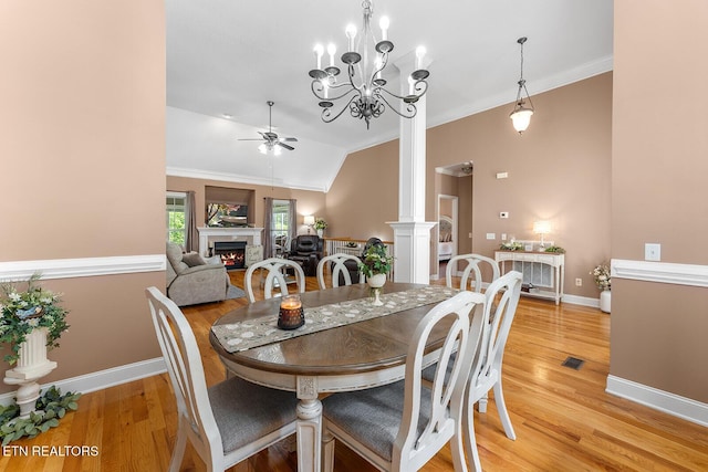 4322 Wellesley Dr, Ooltewah, TN 37363 - dining area featuring ornamental molding, decorative columns, a lit fireplace, light wood finished floors, and ceiling fan with notable chandelier
