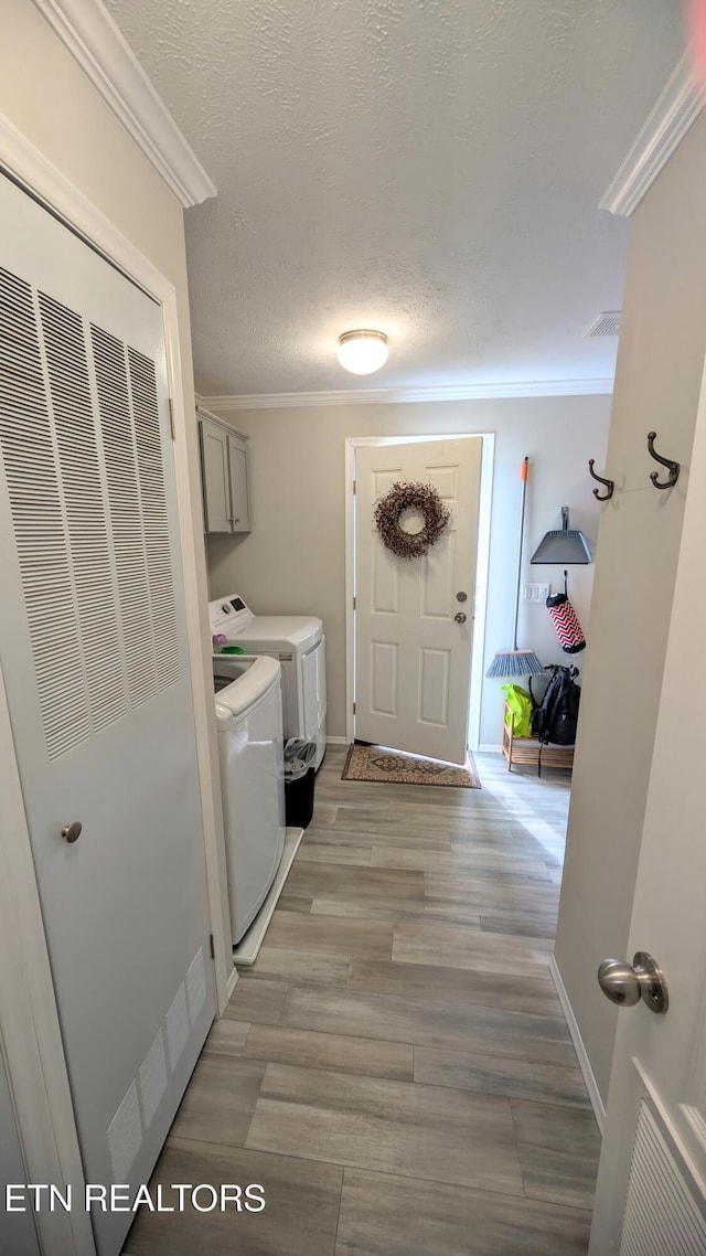 210 Schertz Ln, Rutledge, TN 37861 - laundry area featuring ornamental molding, light wood-style flooring, a textured ceiling, separate washer and dryer, and cabinet space