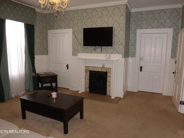 living room with ornamental molding, a chandelier, carpet flooring, wainscoting, and a high end fireplace