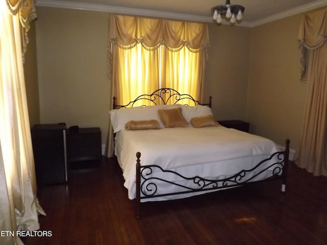 bedroom with wood finished floors and ornamental molding