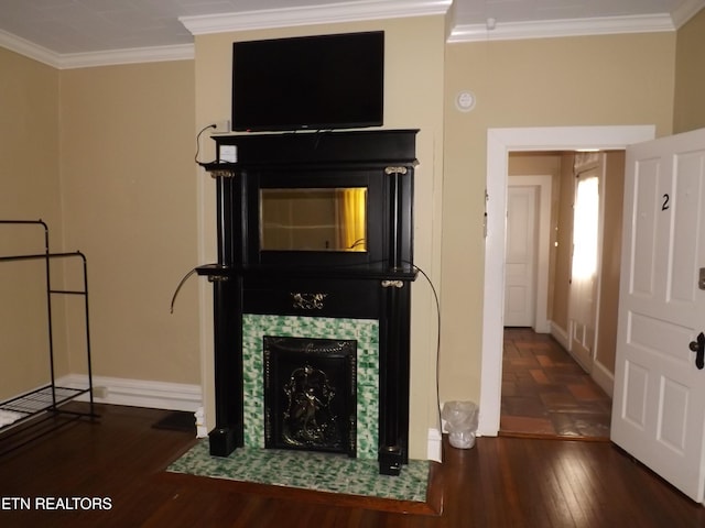 unfurnished living room with wood finished floors, ornamental molding, baseboards, and a tiled fireplace