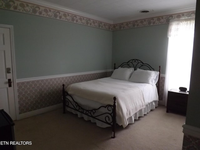 carpeted bedroom with wallpapered walls, ornamental molding, and wainscoting