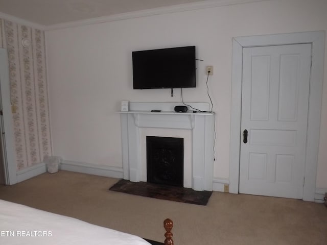 carpeted bedroom with a fireplace with flush hearth and ornamental molding