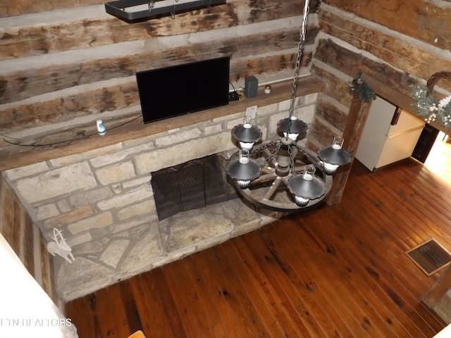 detailed view of wood finished floors, a fireplace, and wood walls