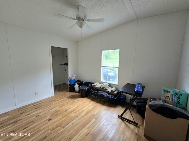 interior space with a textured ceiling, ceiling fan, and hardwood / wood-style floors